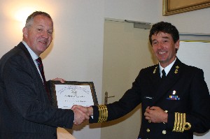 Rear Adm. Willem Voogt, RNLN (Ret.) (l), chapter president, presents a certificate of appreciation to Capt. Huub Geilenkirchen, RNLN, for his presentation and for hosting the chapter in March.
